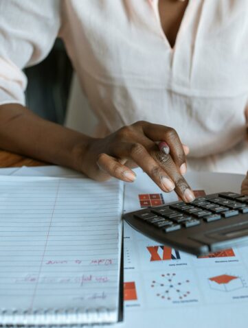 Person in White Dress Shirt Using A Calculator