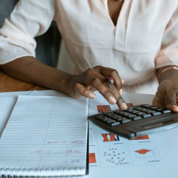 Person in White Dress Shirt Using A Calculator