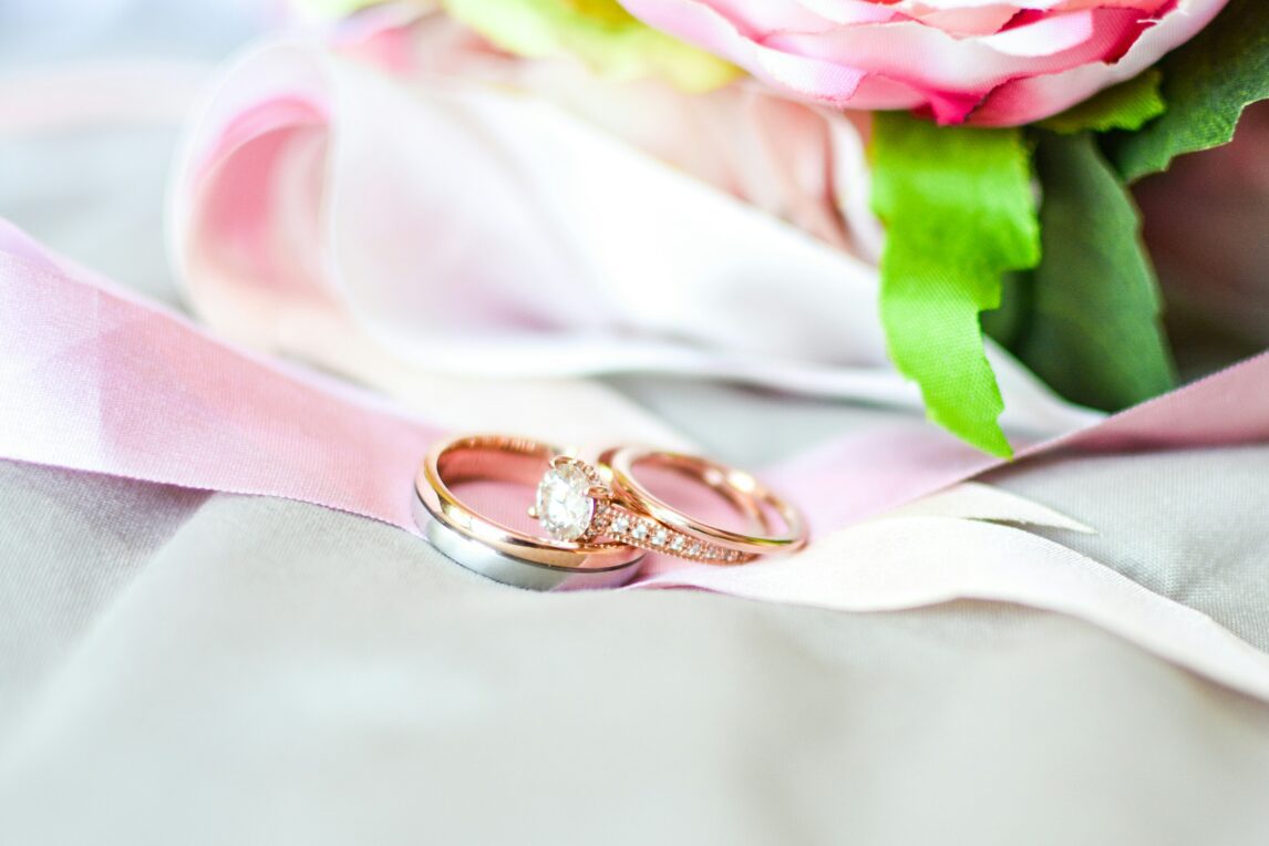 silver-and-gold-colored rings near pink flower