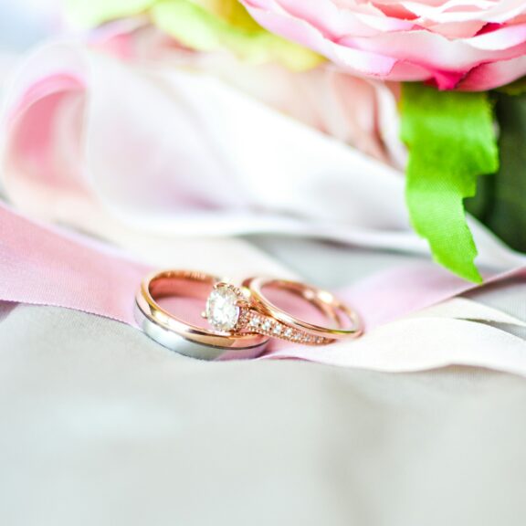 silver-and-gold-colored rings near pink flower