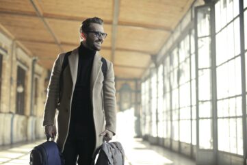 Man in Brown Robe Carrying Bag Smiling