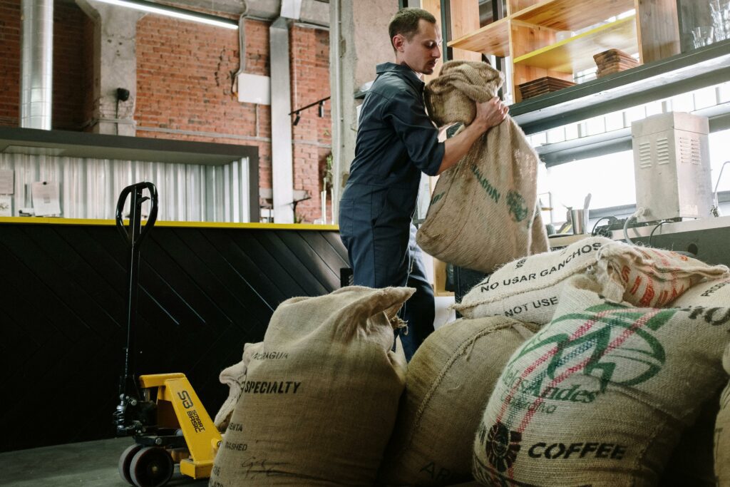 A man lifting bags of coffee for shipping
